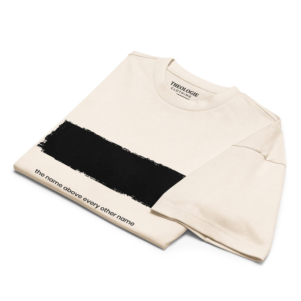 Folded vintage white Theologie Clothing Redacted Christian T-shirt with black chest graphic and Philippians 2:9 text